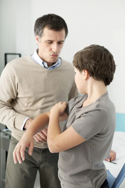 Arts onderzoekt de jongen de hand — Stockfoto