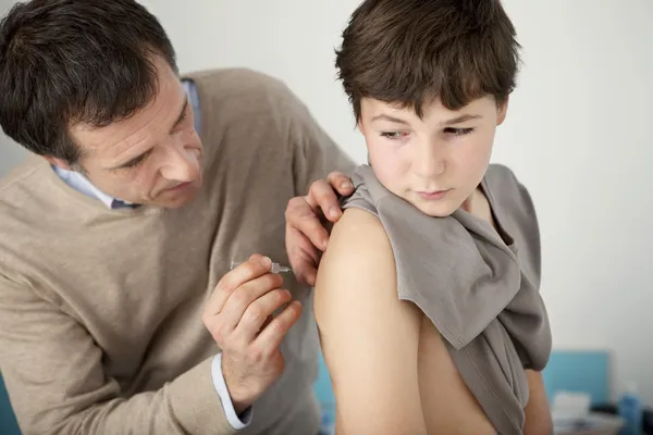 El médico le inyecta al niño. — Foto de Stock