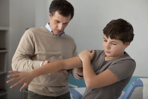 Doctor examines the boy's hand — Stock Photo, Image