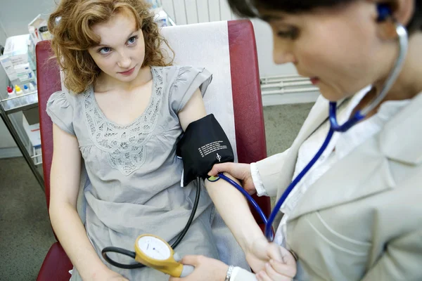 Doctor measures the pressure of the patient Stock Image