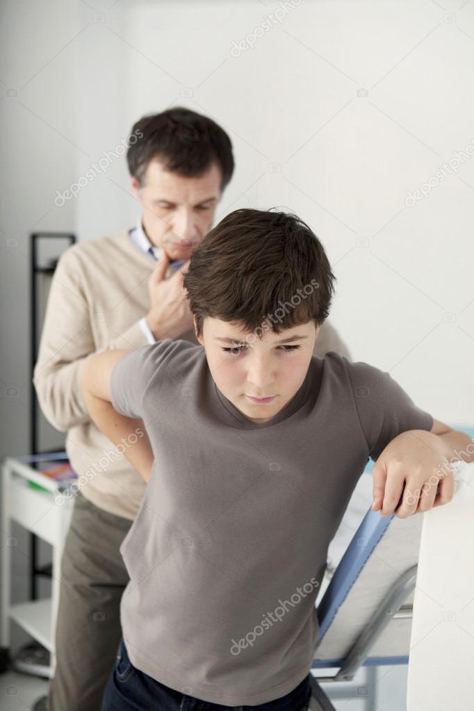 Doctor examines a boy's back