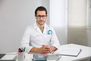 Doktor onun masasında.