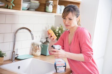 Woman using a conventional cleaning product.