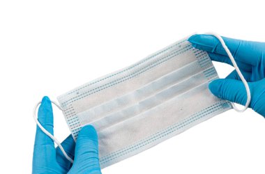 Hand holding a mask for protection against viruses like coronavirus-19 or air pollution.