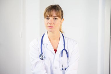 A female doctor in her white coat talking to a patient.