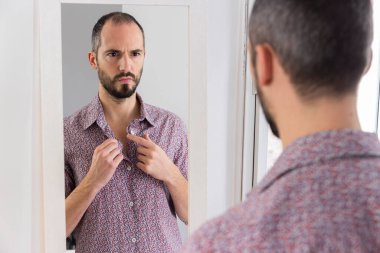 A man looking in a mirror to give him self-confidence.