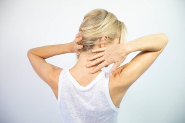 A woman feeling pain in her neck.