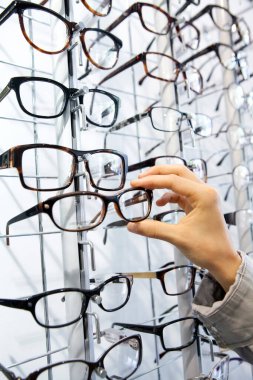 Woman choosing glasses at an optician.