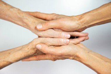 An elderly woman and young womans hands. 