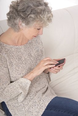 Bir akıllı telefon kullanan üst düzey kadın.