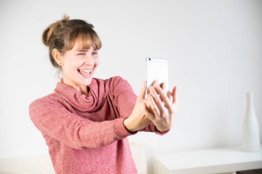 Extremely joyful woman at the sight of her new smartphone.