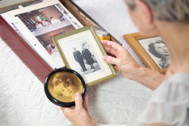 Yaşlı kadın fotoğraflarına bakmaktan.