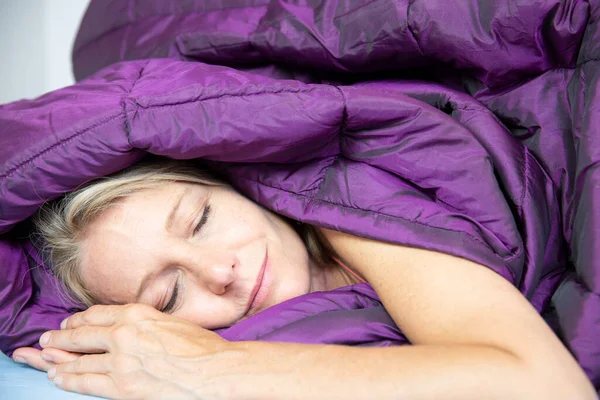 Woman sleeping in a duvet.