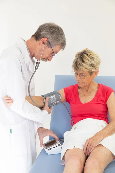 Woman Consulting Doctor Who Taking Her Blood Pressure — Stock fotografie