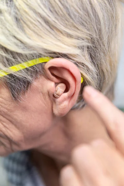 Woman Placing Hearing Aid Her Ear — Zdjęcie stockowe