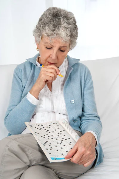 Senior Woman Doing Crossword Puzzle — Zdjęcie stockowe