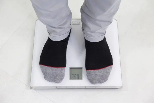 Man on weight scale.