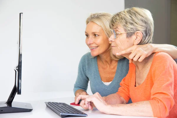 Woman Her Fifties Helping Elderly Woman Use Computer — Stockfoto