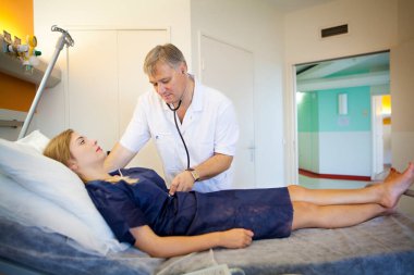 Un mdecin verrifie les constantes d'une patiente avant son entr au bloc opratoire. 