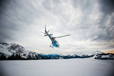 The trackers ensure the safety of the slopes for the skiers, a helicopter evacuates an injured person.