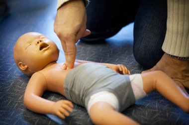 First aid training: cardiac massage on an infant.