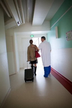 Un mdecin raccompagne une patiente  la sortie de l'hopital. 