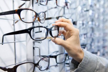 Woman choosing glasses at an optician.