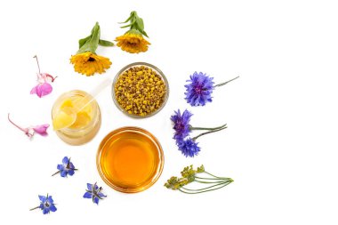 Variety of raw organic honey bee products board surrounded by flowers on white