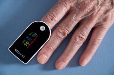 Oximeter attached to the index finger to measure the oxygen level in the blood.