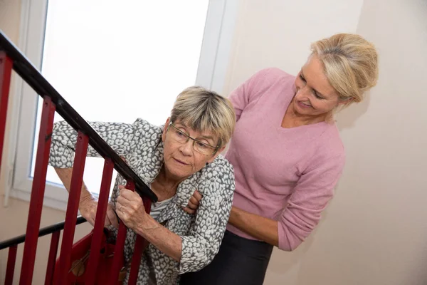 Elderly Woman Being Helped Another Woman Climb Stairs —  Fotos de Stock