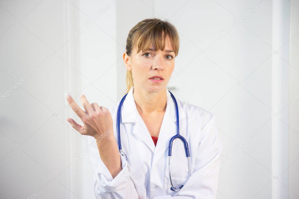 A female doctor in her white coat talking to a patient.