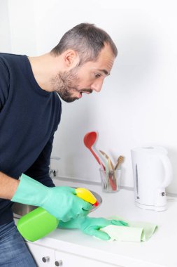A man using cleaning products to clean.