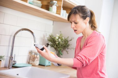 Woman using a conventional cleaning product.