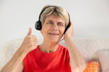 A woman expressing joy while listening to music in headphones.