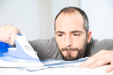 A man ironing carefully ironing his short.