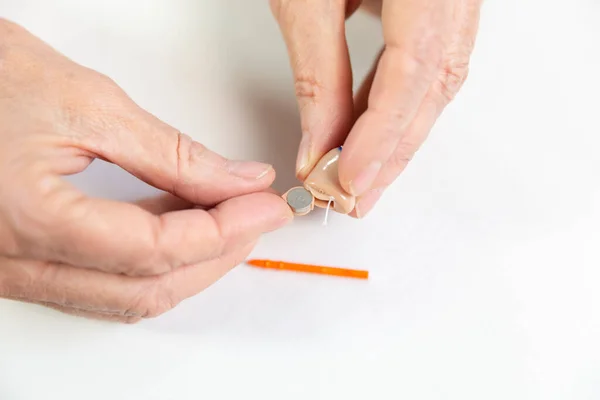 Changing a hearing aid battery. close-up view