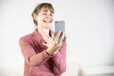 Extremely joyful woman at the sight of her new smartphone.