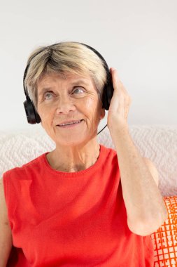 A woman expressing joy while listening to music in headphones.