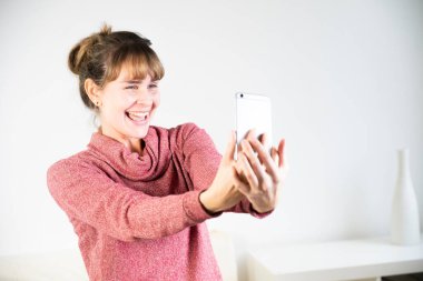 Extremely joyful woman at the sight of her new smartphone.