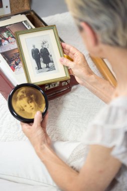 Yaşlı kadın fotoğraflarına bakmaktan.