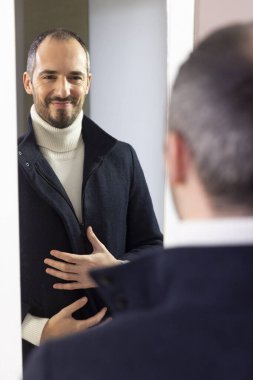 A man looking at himself in the mirror for self-confidence.