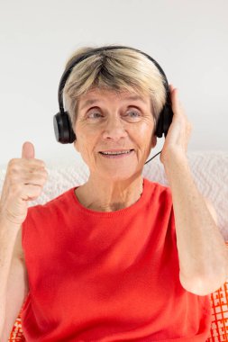 A woman expressing joy while listening to music in headphones.