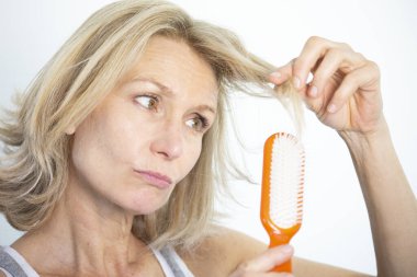 Woman looking at her split ends.