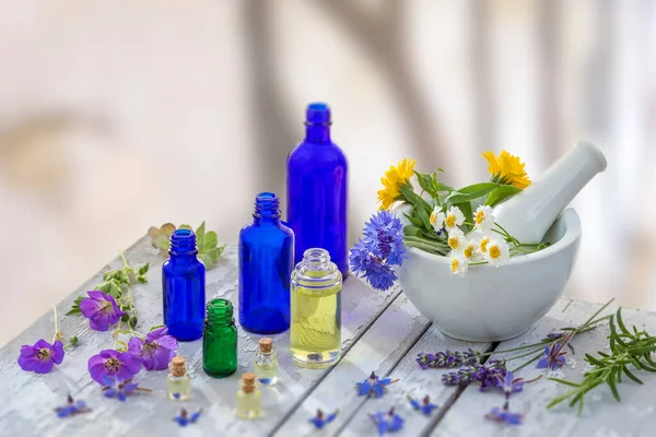 Essential oil and perfume from medicinal plant in mortar surrounded by petals