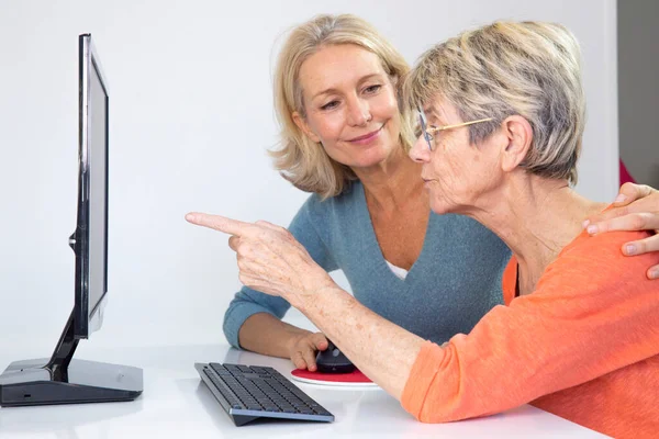 Woman Her Fifties Helping Elderly Woman Use Computer — Zdjęcie stockowe