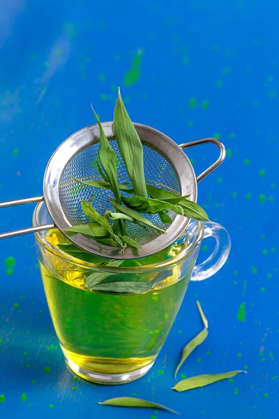 Close up of bamboo leaves above the bamboo infusion cup.