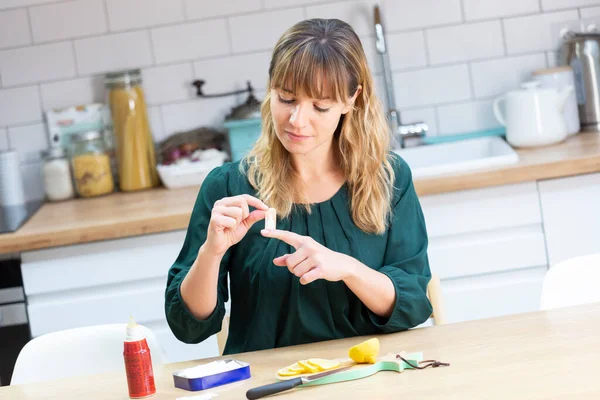 Young Woman Her Kitchen Putting Bandaid Cutting Herself — Zdjęcie stockowe