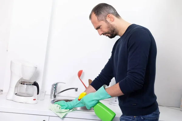 A man using cleaning products to clean.