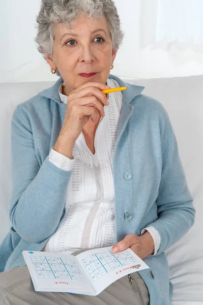 Senior Woman Playing Sudoku — Stockfoto