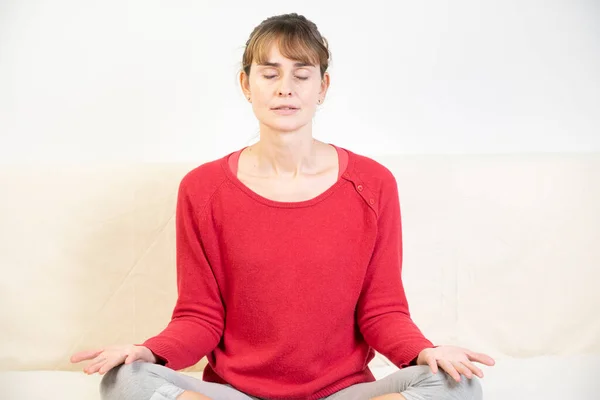 Woman sitting facing front during a meditation session.